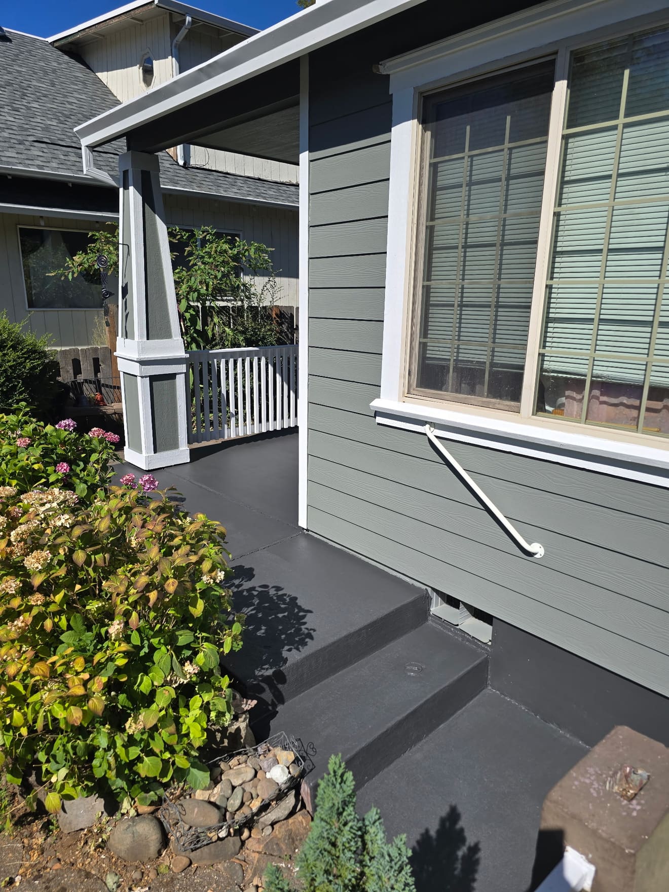Front porch after refinishing — charcoal floor with white columns