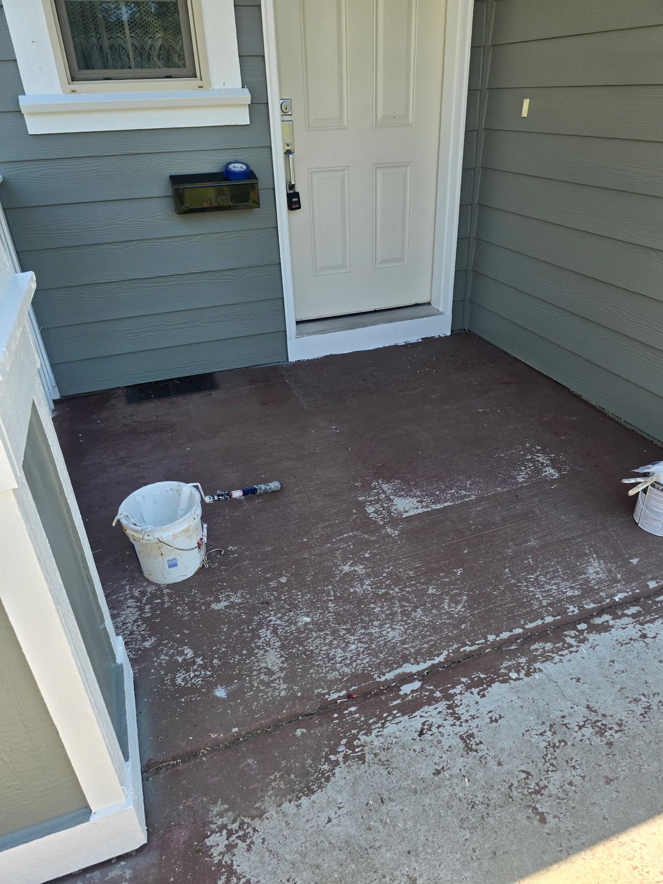 Front porch floor before refinishing — worn red-brown coating