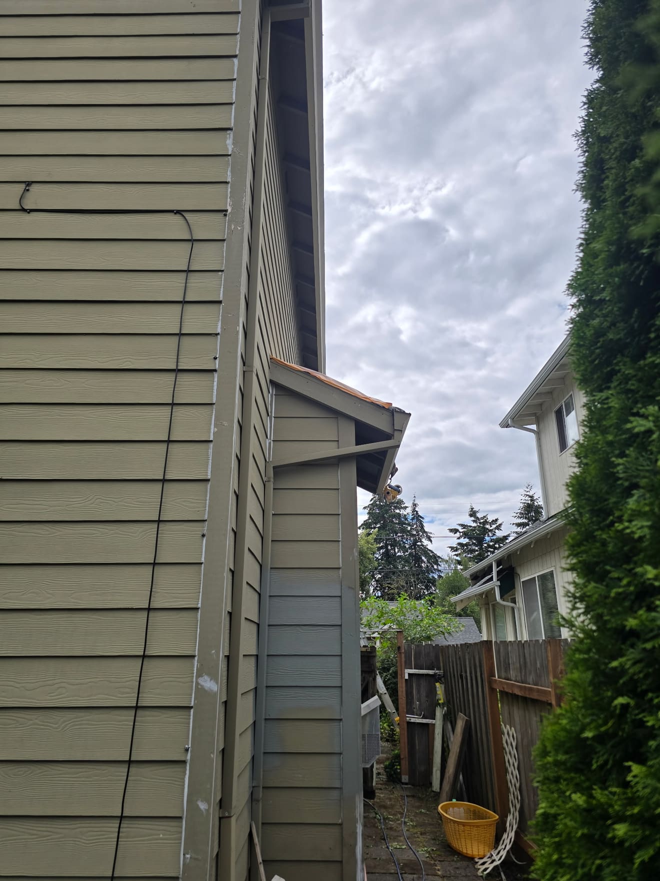 Narrow side of a Beaverton home before painting — faded olive siding