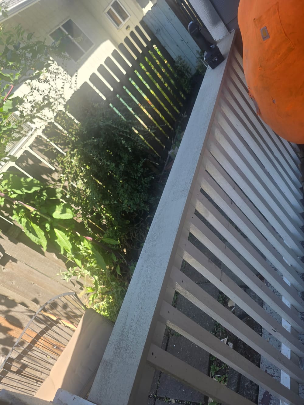 Scraping and sanding a deck railing before repainting