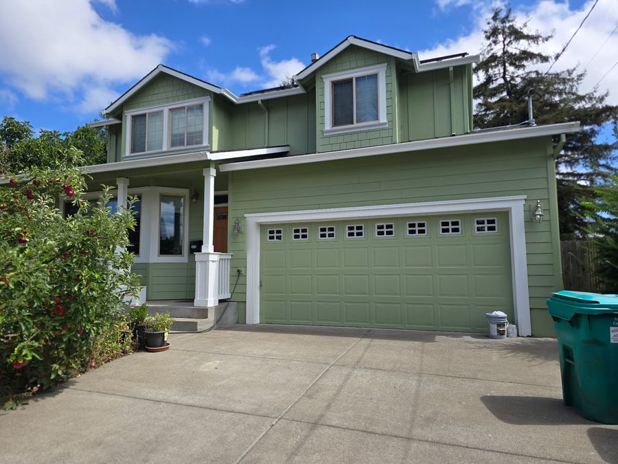 The same house after: sage green siding with white trim